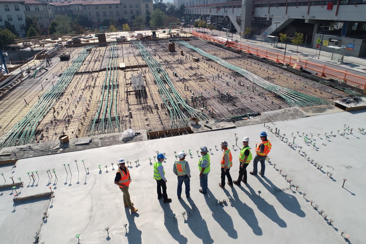 A construction site with a reinforced slab and a small group reviewing the works.