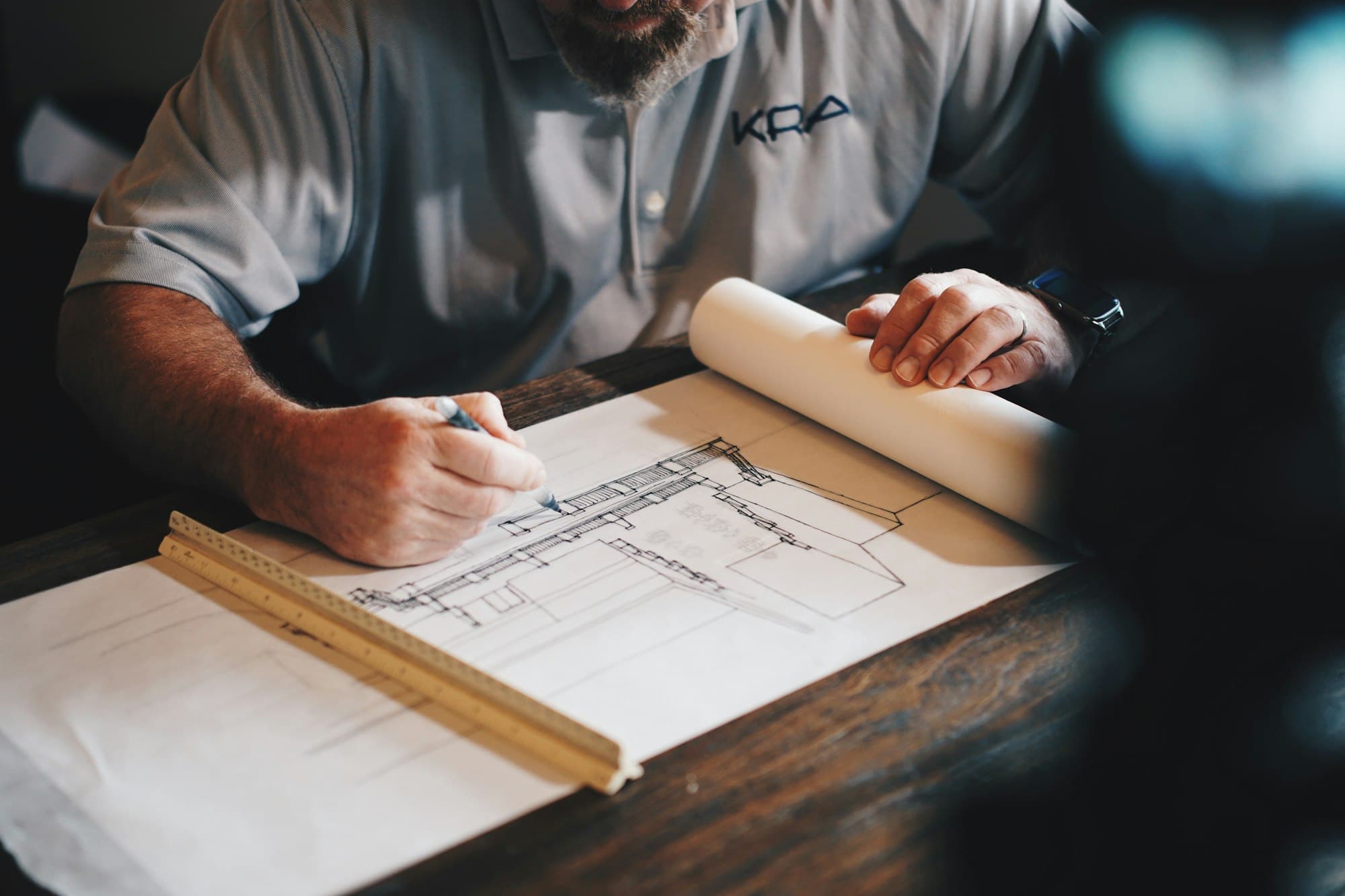 An architect marking a drawing — project work before it becomes a building.